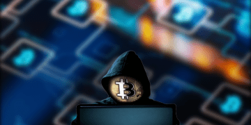 Hacker on computer with Bitcoin (Blockchain) Background