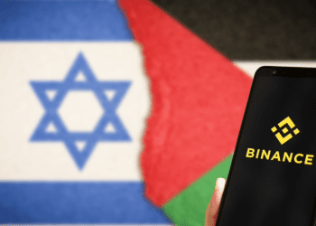 Binance Logo on phone with Flags in Background