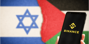 Binance Logo on phone with Flags in Background