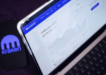 Kraken Logo on Phone with Desktop Site in Background