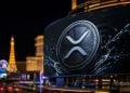 Ripple (XRP) coin on a large digital billboard with water splash, city lights in the background, Las Vegas skyline at night