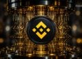 Close-up of a black Binance logo disk with a yellow diamond pattern, set in a gold-lit circuitry frame.