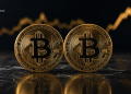 Two gold Bitcoin coins on a dark surface with a gold upward-trending chart in the background, plus a BLOCKNEWS watermark in the top-left corner (informative visual).