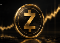 Close-up of a Zcash gold coin with a large Z symbol, glowing edges on a dark, reflective surface.