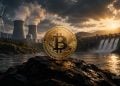A large Bitcoin coin on a rock beside a river at sunset, with wind turbines and a dam in the background.