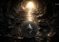 Ethereum coin resting in a dark rocky cavern, with a warm glow coming from a tunnel ahead. The logo faces the viewer. The scene suggests crypto mining or discovery in a cave with BLOCKNEWS branding.