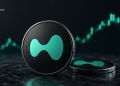 Close-up of a Ripple (XRP) coin with a teal logo on a dark surface, with a rising teal price chart in the background
