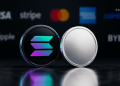 Close-up of two coins on a dark surface: left coin shows a colorful Solana logo, right coin is plain silver, blurred payment logos in background.