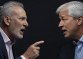 Two suited men face off in a tense confrontation, one pointing a finger as they speak angrily at close range.