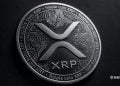 Close-up of a silver XRP coin with circuit patterns and Ripple coin XRP text on a dark background.