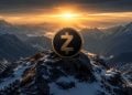 Gold and black coin with a bold Z emblem on a snowy mountaintop at sunset, rugged alpine backdrop.