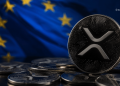 Close-up of a shiny Ripple XRP coin leaning on euro coins with a blurred European flag in the background.